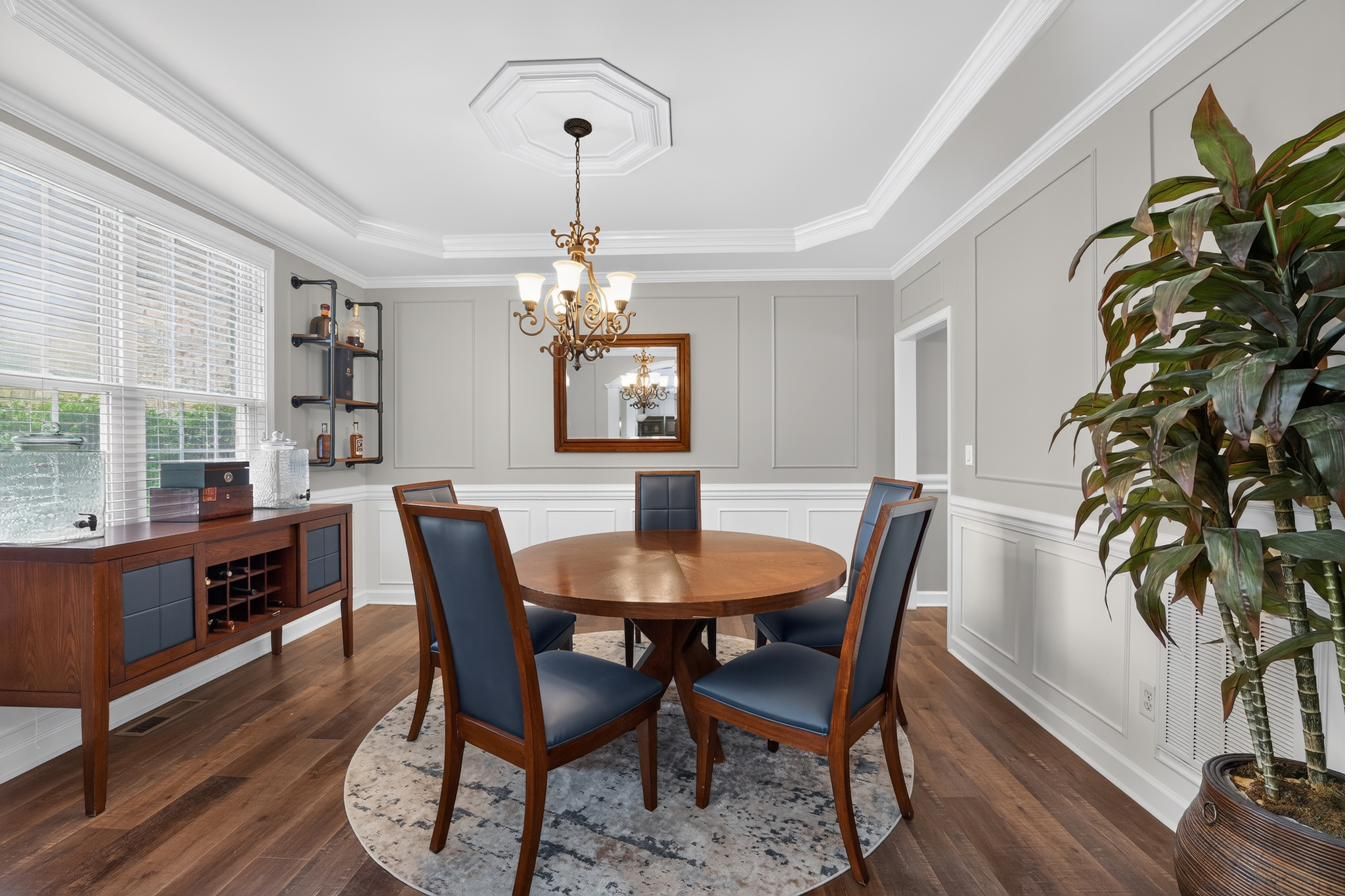 Formal dining room with tray ceiling and wainscoting